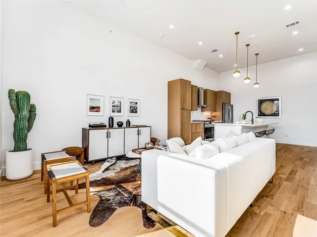 a living room with furniture a table and kitchen view