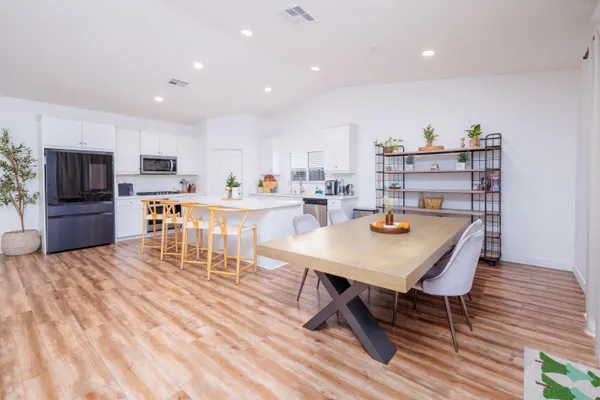 a living room with stainless steel appliances kitchen island granite countertop furniture and a dining table