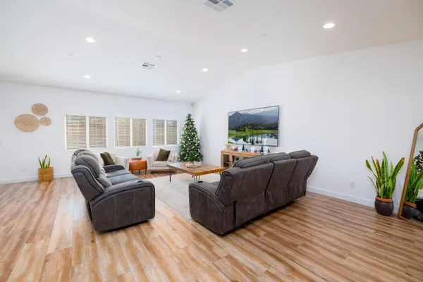 a living room with furniture and a wooden floor