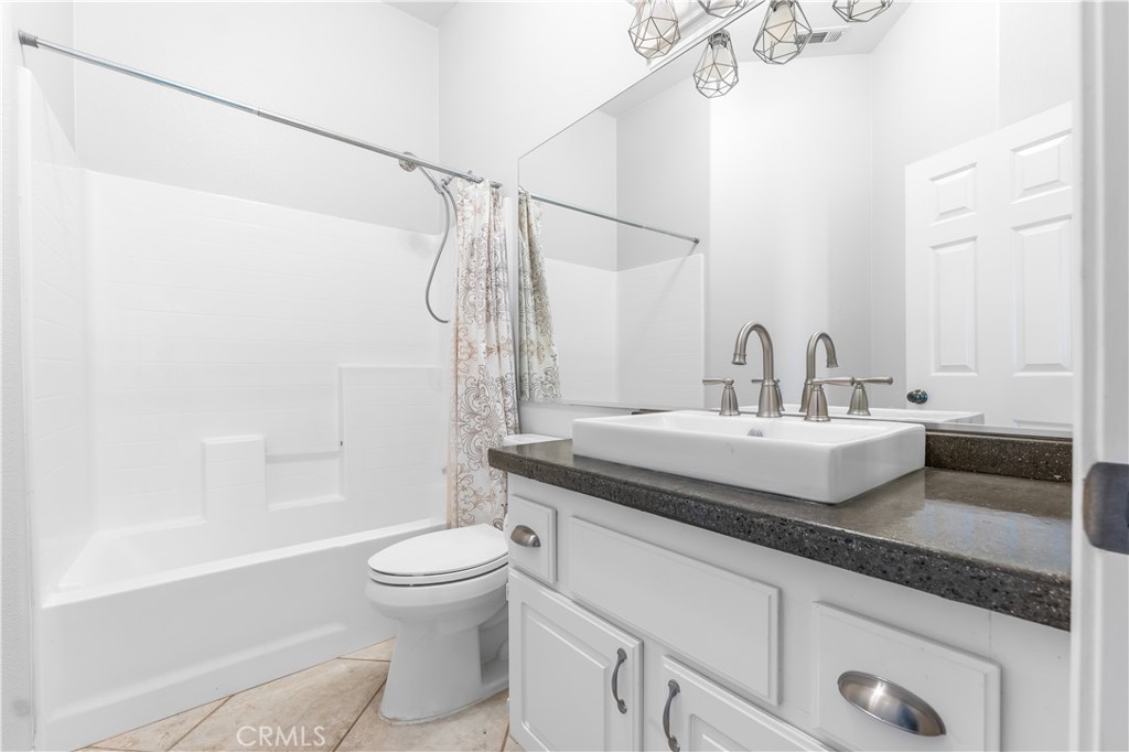 40445 Chantemar Way Temecula, CA 92591 - Photo 23 of 28 a bathroom with a granite countertop sink a toilet and shower