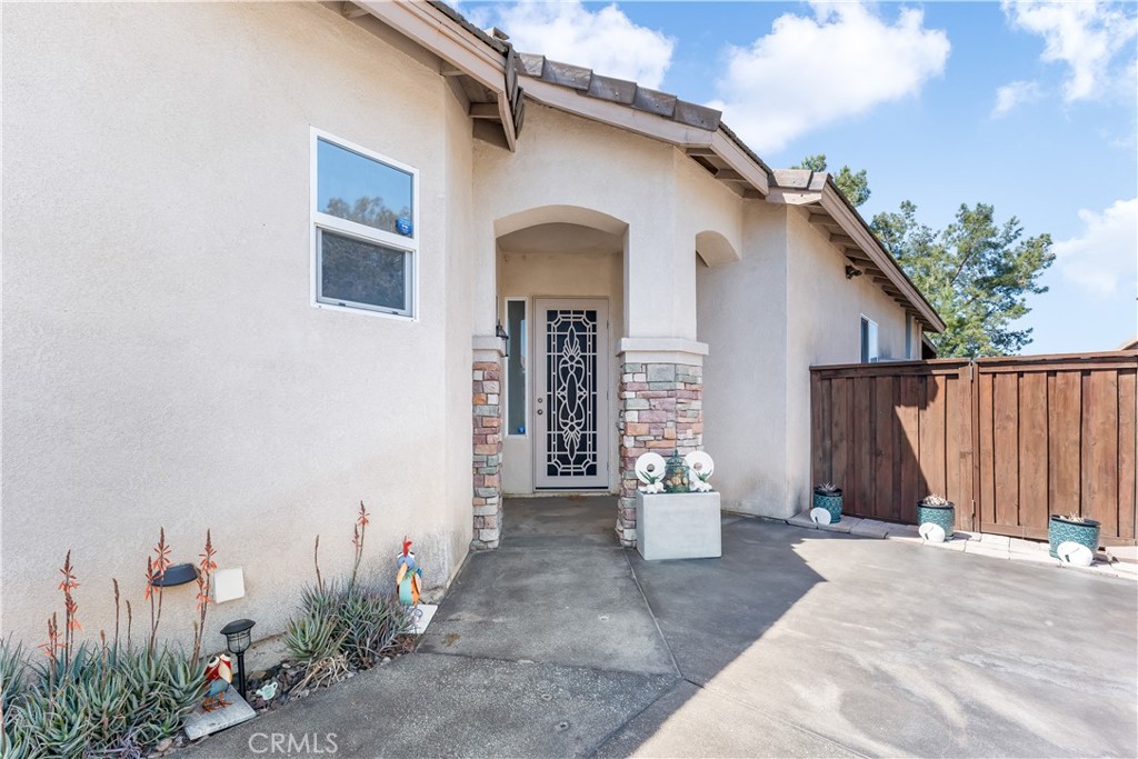 40445 Chantemar Way Temecula, CA 92591 - Photo 6 of 28 a view of a white house with wooden walls and potted plants