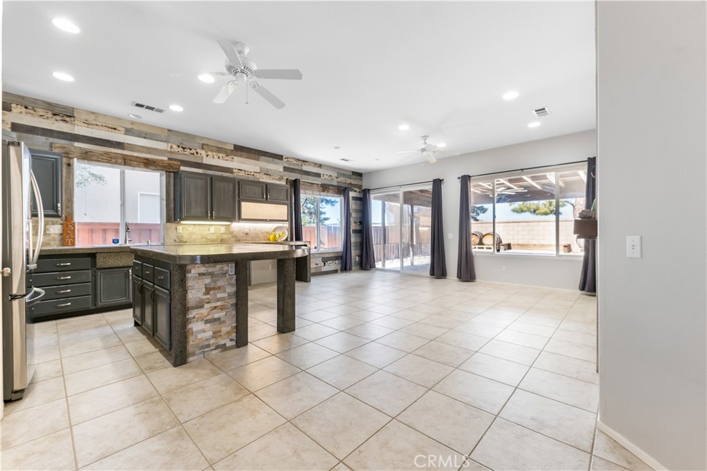 40445 Chantemar Way Temecula, CA 92591 - Photo 8 of 28 a large kitchen with kitchen island granite countertop a large window and a counter top space