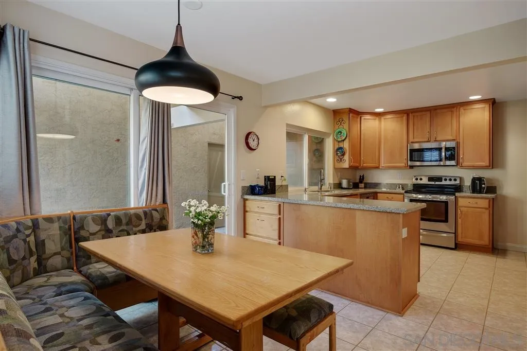 210 Countryhaven Road Encinitas, CA 92024 - Photo 7 of 25 a kitchen with a table chairs microwave and cabinets