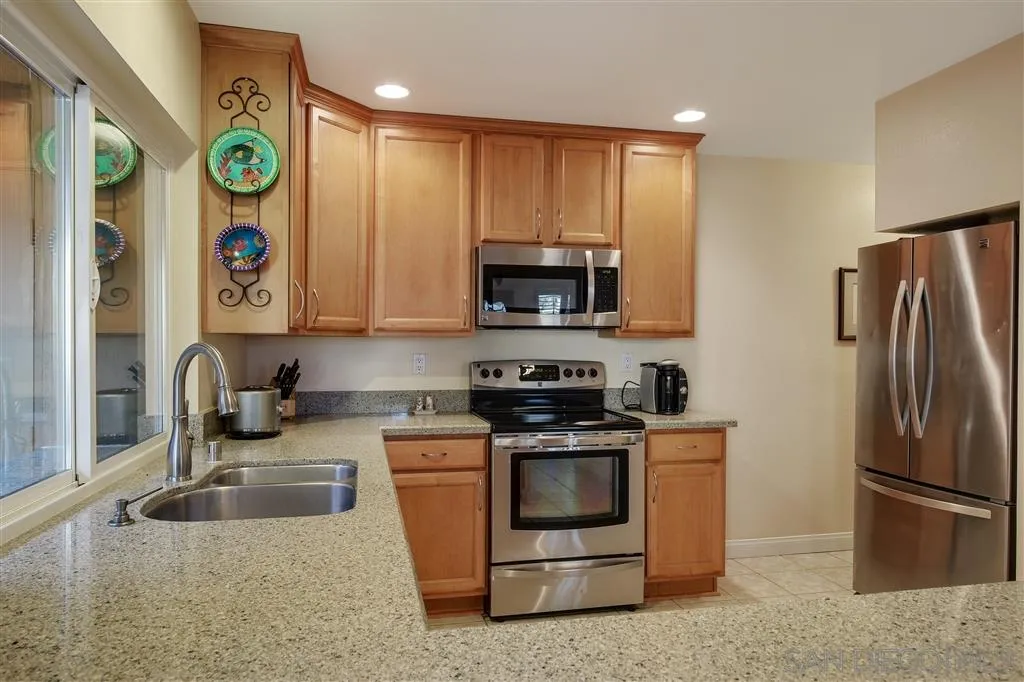 210 Countryhaven Road Encinitas, CA 92024 - Photo 10 of 25 a kitchen with stainless steel appliances granite countertop a refrigerator a stove top oven a sink and a window