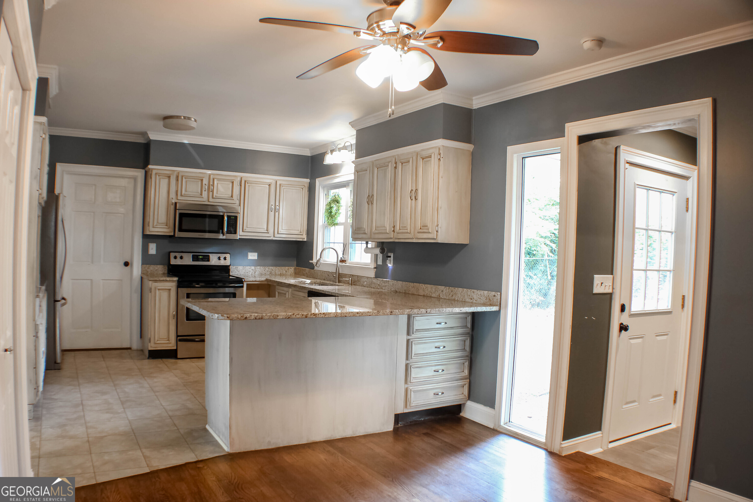 311 Roswell Avenue Southeast Rome, GA 30161 - Photo 8 of 21 a kitchen with kitchen island granite countertop a stove top oven a sink and cabinets