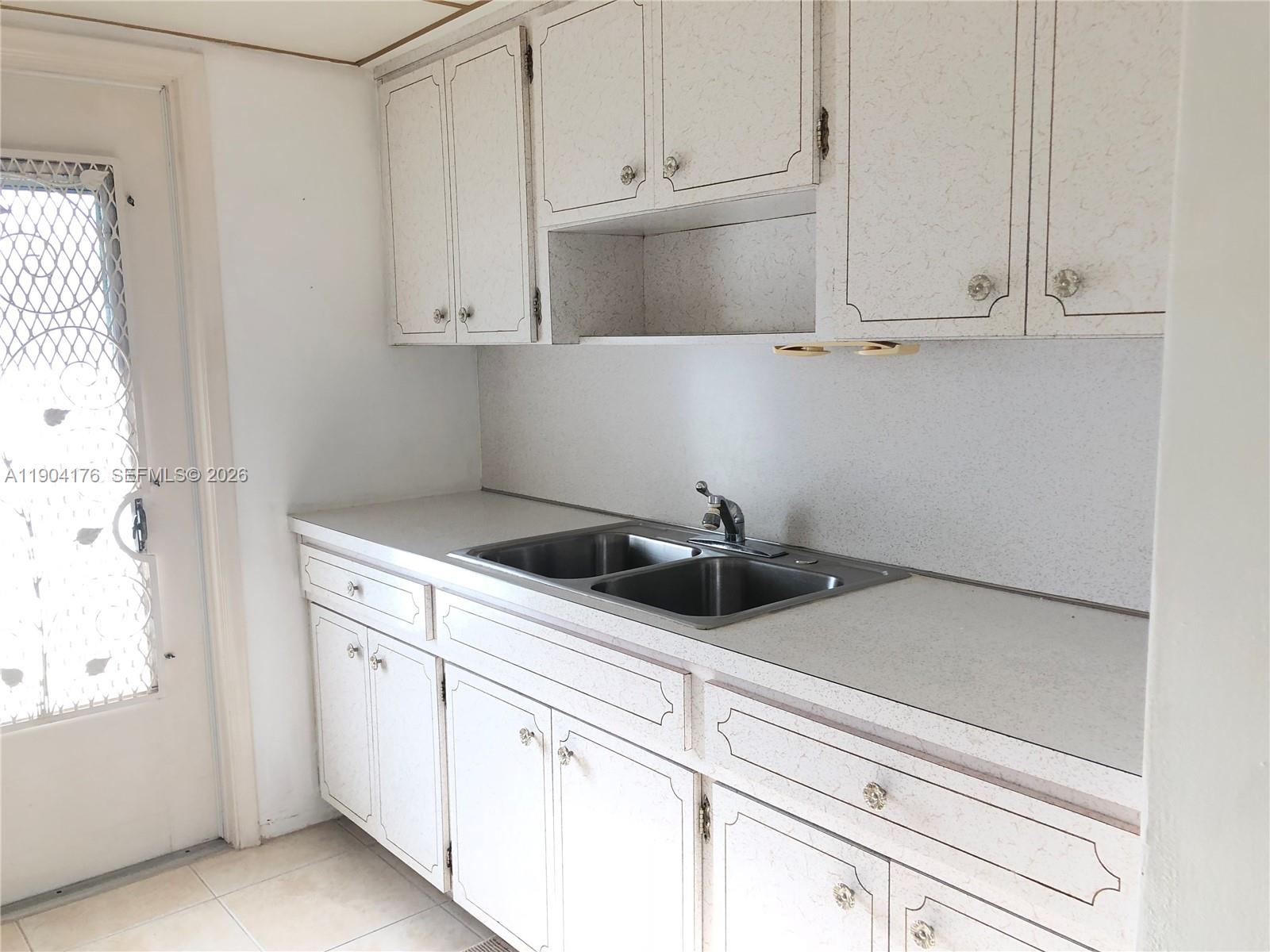 1836 Arthur Street, Unit 20 Hollywood, FL 33020 - Photo 13 of 19 a kitchen with white cabinets and sink