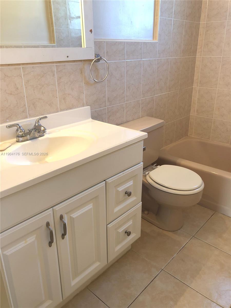1836 Arthur Street, Unit 20 Hollywood, FL 33020 - Photo 15 of 19 a bathroom with a sink a toilet and a mirror