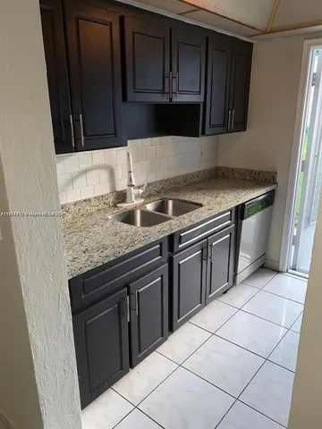 a kitchen with granite countertop a stove top oven microwave and cabinets
