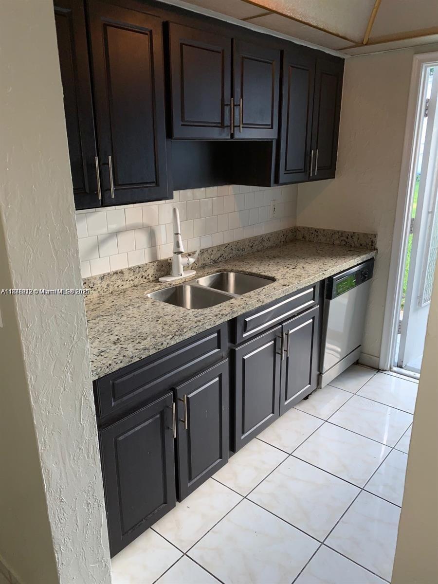 1850 Arthur Street, Unit 2 Hollywood, FL 33020 - Photo 1 of 20 a kitchen with granite countertop a stove top oven microwave and cabinets