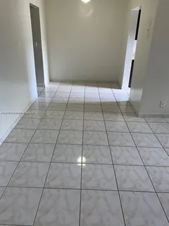 a view of an empty room with white tiles