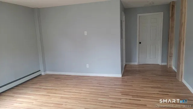 a view of an empty room with wooden floor