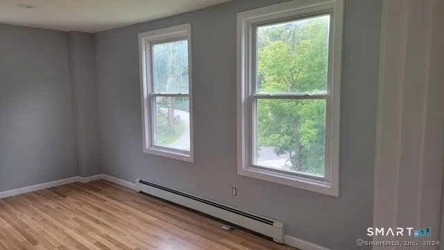 a view of empty room with wooden floor
