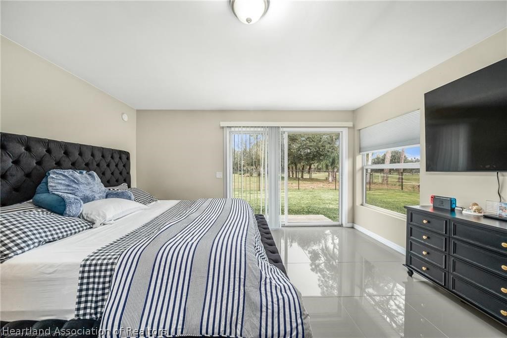 3824 Westminster Road Sebring, FL 33875 - Photo 19 of 30 a bedroom with a bed and glass windows