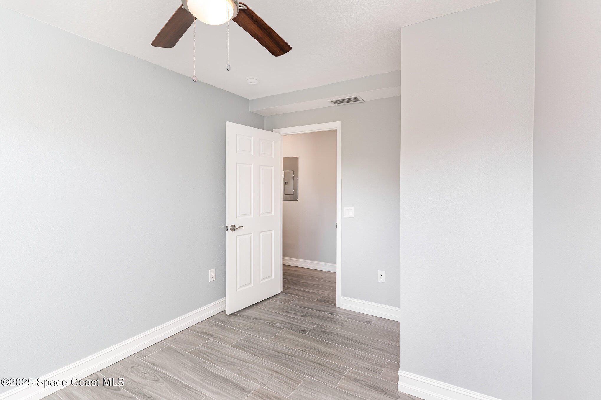 2566 Spence Drive Northeast Palm Bay, FL 32905 - Photo 13 of 20 a view of an empty room with wooden floor