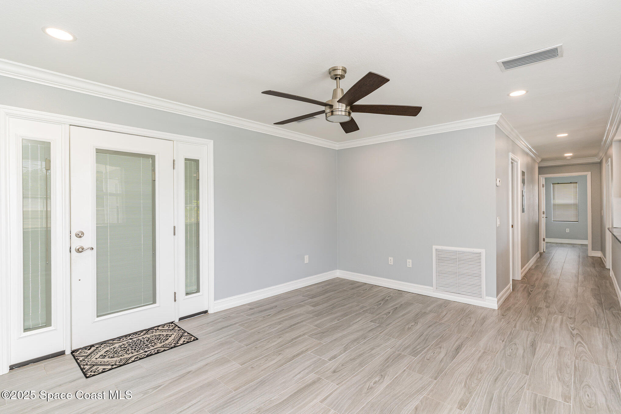 2566 Spence Drive Northeast Palm Bay, FL 32905 - Photo 3 of 20 a view of a big room with wooden floor and a ceiling fan
