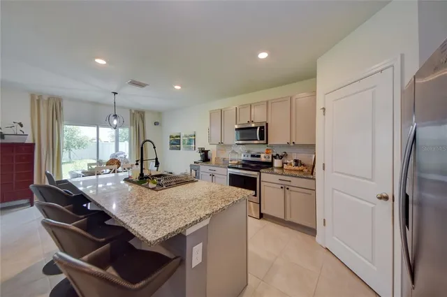 a kitchen with refrigerator cabinets dining table and chairs