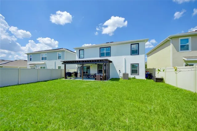 a view of a house with backyard and sitting area