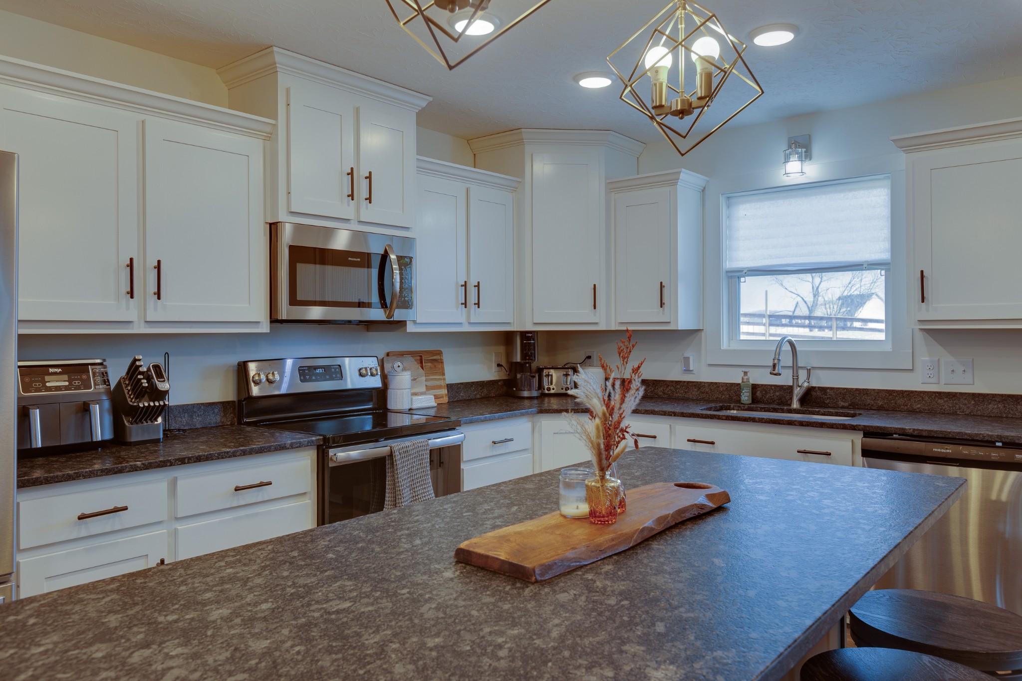 500 Armstrong Road Castalian Springs, TN 37031 - Photo 11 of 35 a kitchen with kitchen island granite countertop stainless steel appliances a sink a stove a microwave a refrigerator and cabinets