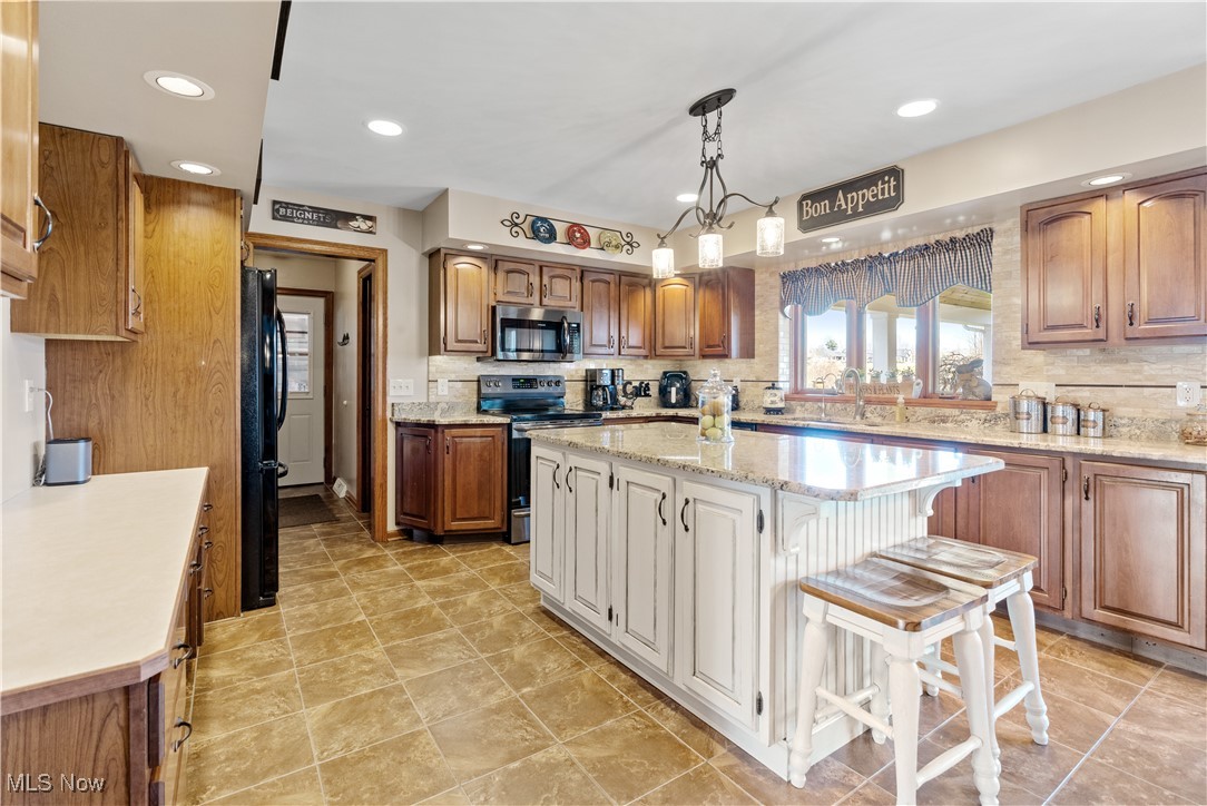 7285 South Raccoon Road Canfield, OH 44406 - Photo 10 of 46 Kitchen with stainless steel appliances, a kitchen island, tasteful backsplash, recessed lighting, and pendant lighting