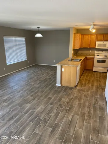 a kitchen with granite countertop a stove a sink and a refrigerator