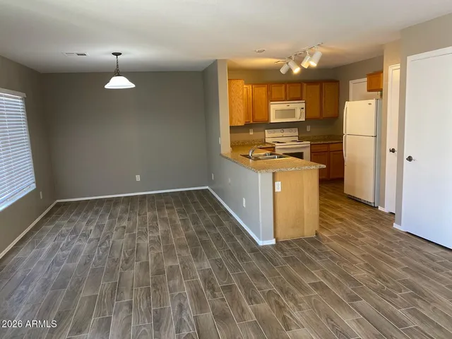 a kitchen with kitchen island granite countertop wooden floors and a sink