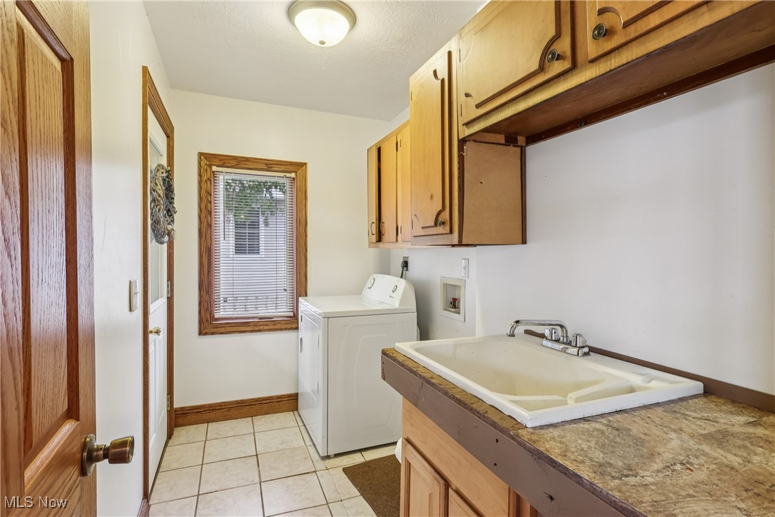 337 Cedar Point Road Sandusky, OH 44870 - Photo 19 of 50 Laundry area with washer / clothes dryer, light tile patterned flooring, and cabinet space