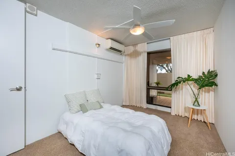 a bedroom with a bed and a potted plant