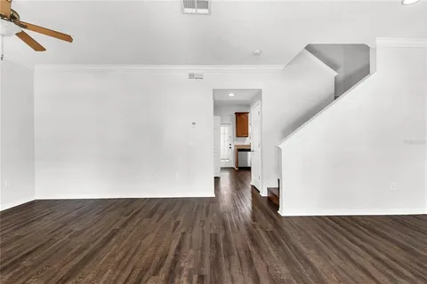 an empty room with wooden floor and white walls
