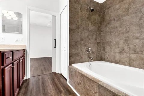 a spacious bathroom with a granite countertop sink toilet a mirror and bathtub