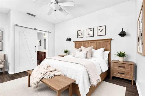 a view of an empty room with wooden floor and a ceiling fan