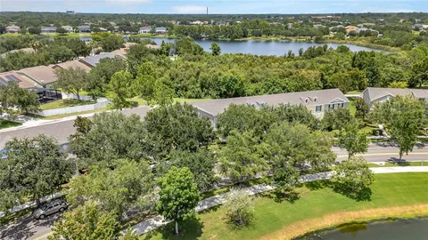 an aerial view of residential houses with outdoor space and lake view