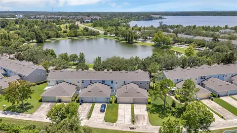 an aerial view of residential houses with outdoor space and lake view