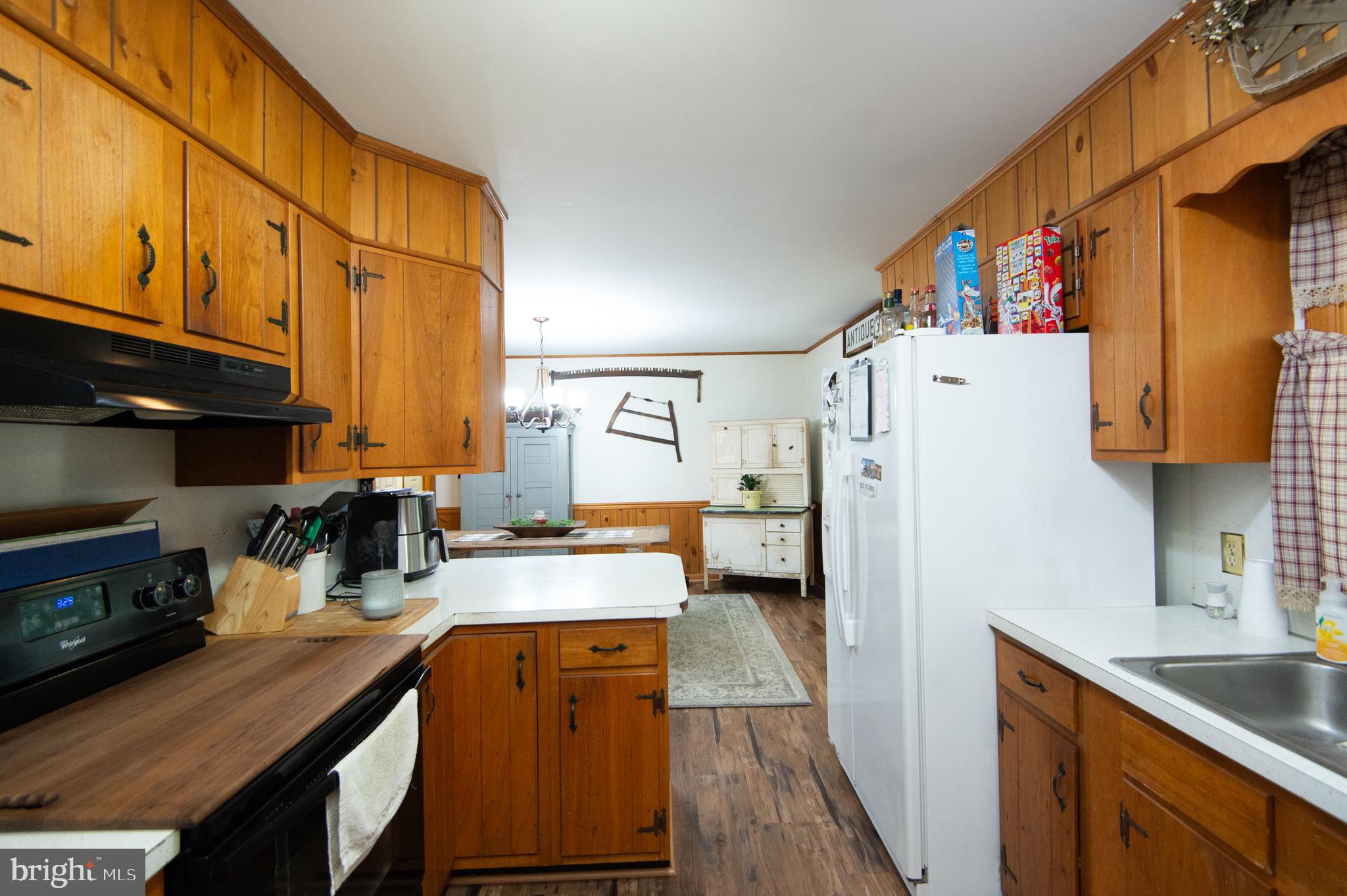 5802 Phyllis Drive Hurlock, MD 21643 - Photo 11 of 26 a kitchen with a refrigerator a stove a sink dishwasher and wooden cabinets with wooden floor
