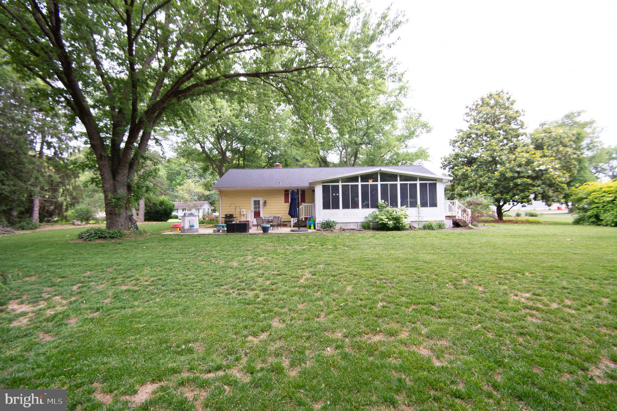 5802 Phyllis Drive Hurlock, MD 21643 - Photo 23 of 26 a front view of a house with a yard table and trees