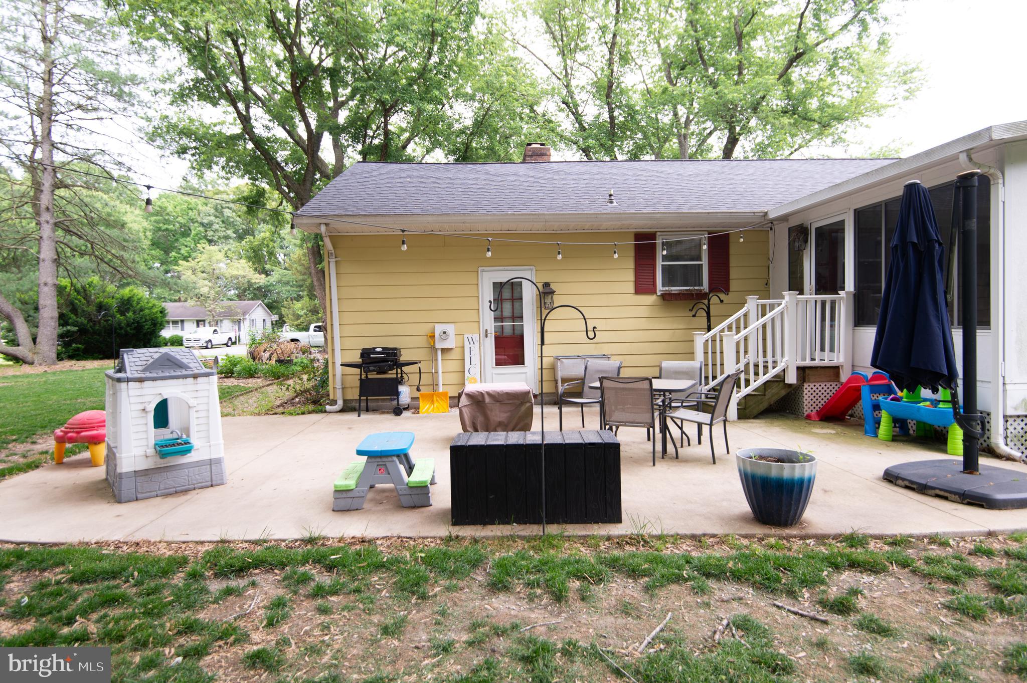 5802 Phyllis Drive Hurlock, MD 21643 - Photo 24 of 26 a view of a patio with table and chairs potted plants and a large tree