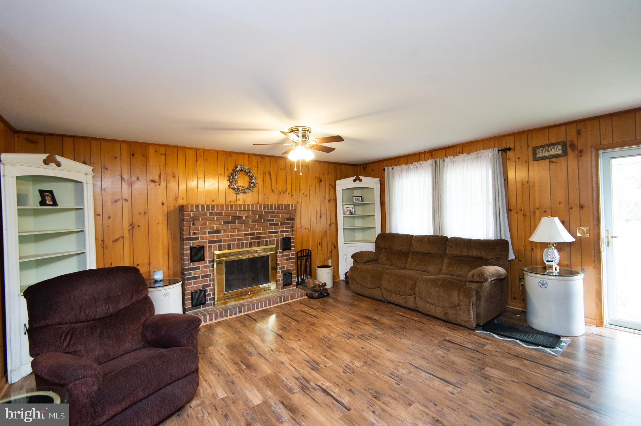 5802 Phyllis Drive Hurlock, MD 21643 - Photo 5 of 26 a living room with furniture a fireplace and a flat screen tv
