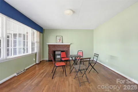 a workspace with furniture a fireplace and wooden floor