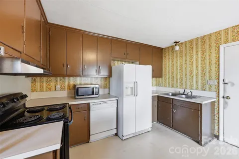 a kitchen with a sink a refrigerator and cabinets