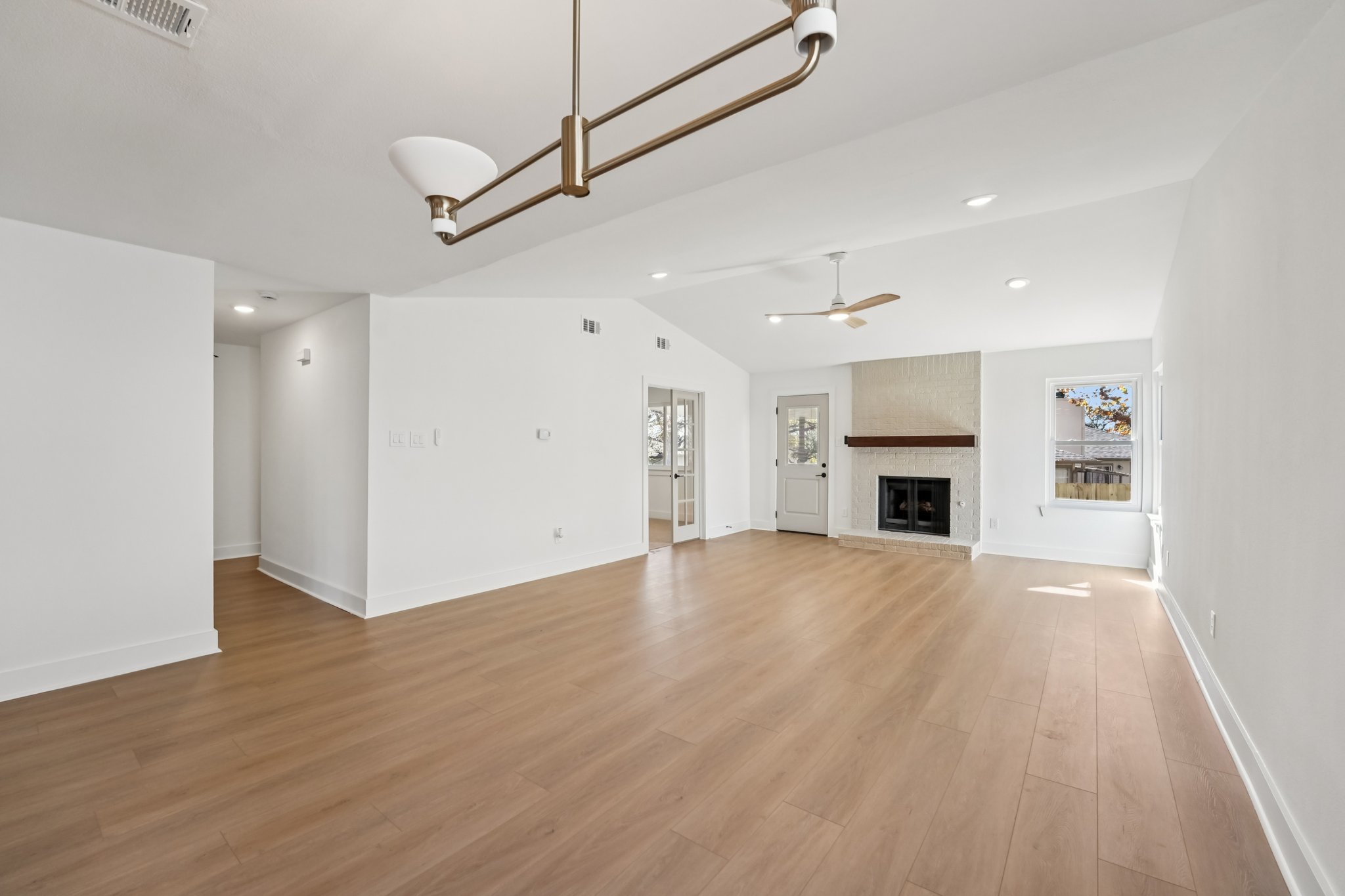4901 Transit Circle Austin, TX 78727 - Photo 16 of 29 an empty room with wooden floor fireplace and windows