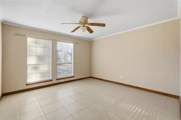 an empty room with windows and chandelier fan