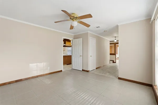 an empty room with closet and ceiling fan