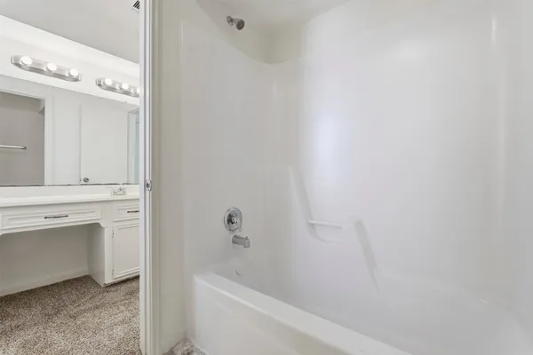 a bathroom with a bathtub sink vanity and toilet