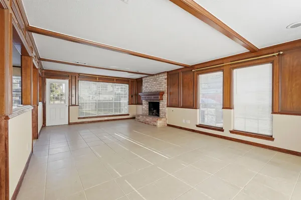 a view of an empty room with a fireplace and a window