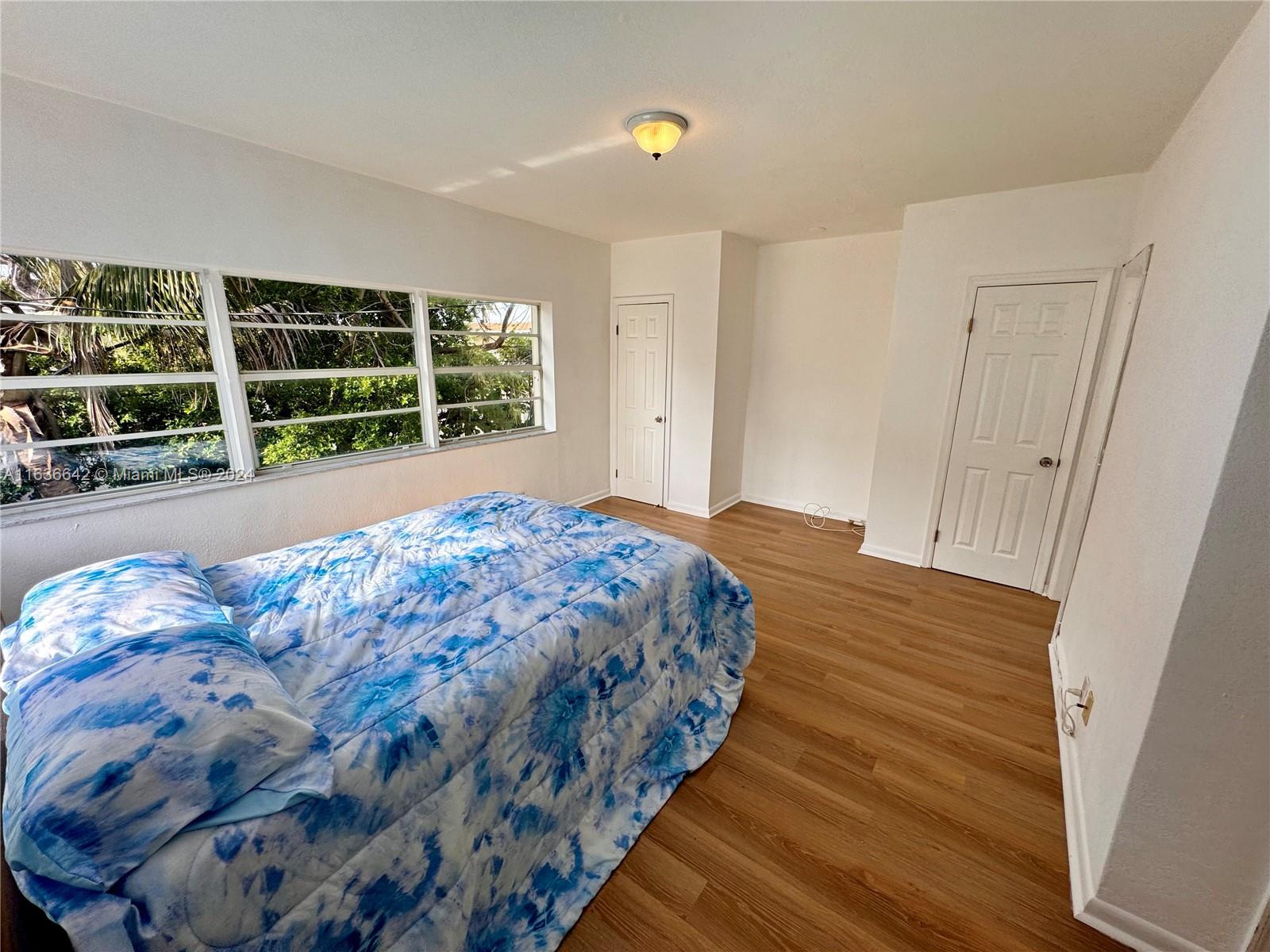 934 79th Terrace, Unit 2 Miami Beach, FL 33141 - Photo 11 of 42 a bedroom with a bed and a large window