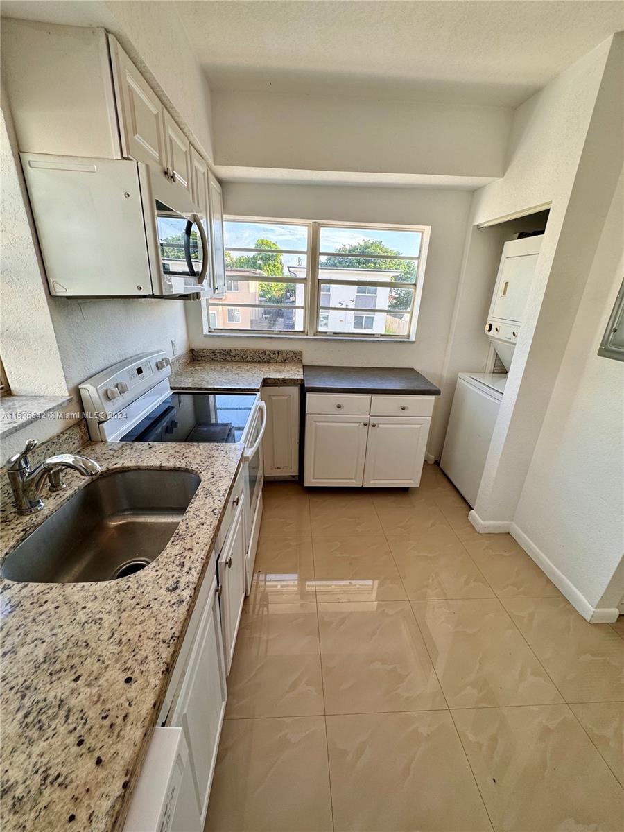 934 79th Terrace, Unit 2 Miami Beach, FL 33141 - Photo 26 of 42 a kitchen with a sink a stove and cabinets