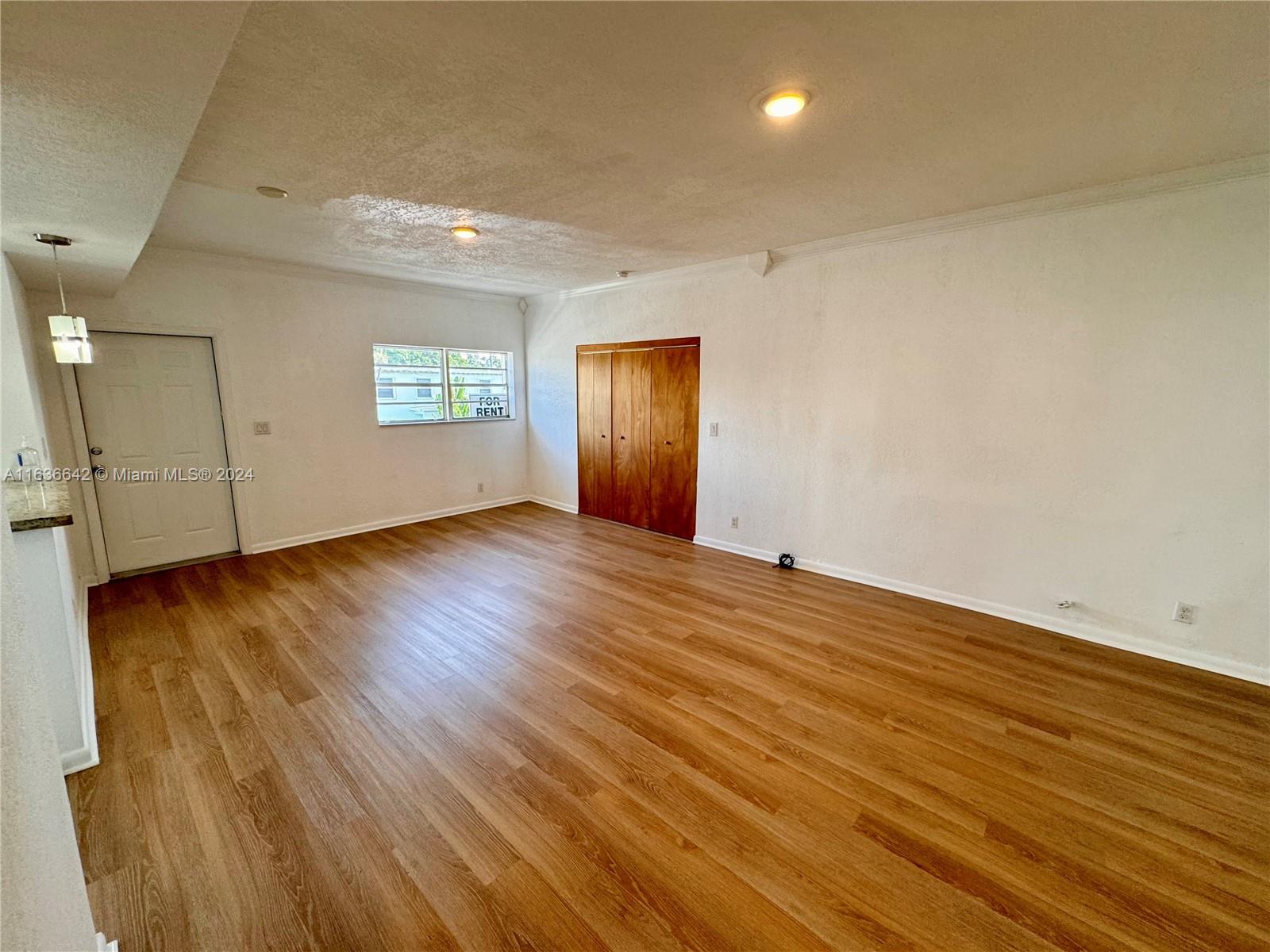 934 79th Terrace, Unit 2 Miami Beach, FL 33141 - Photo 5 of 42 an empty room with wooden floor and windows