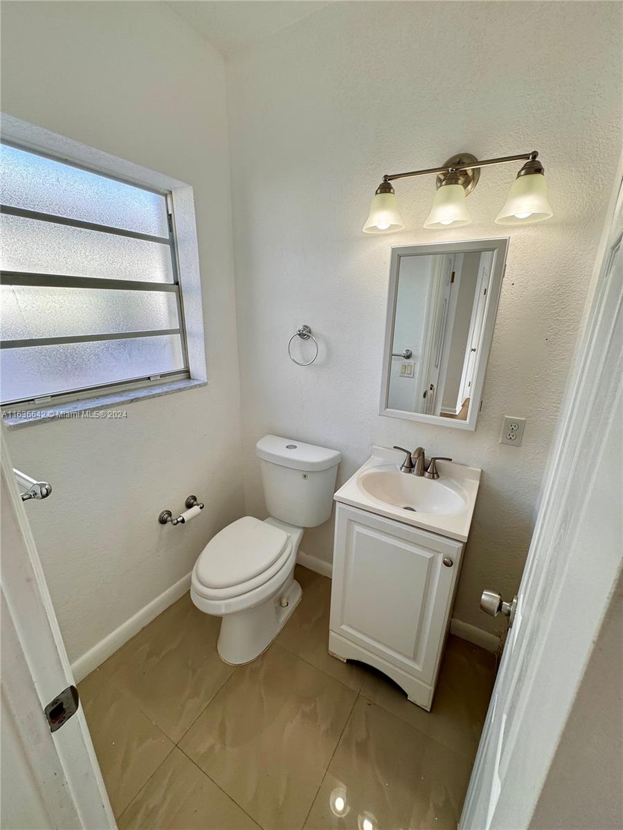 934 79th Terrace, Unit 2 Miami Beach, FL 33141 - Photo 8 of 42 a bathroom with a sink toilet and mirror
