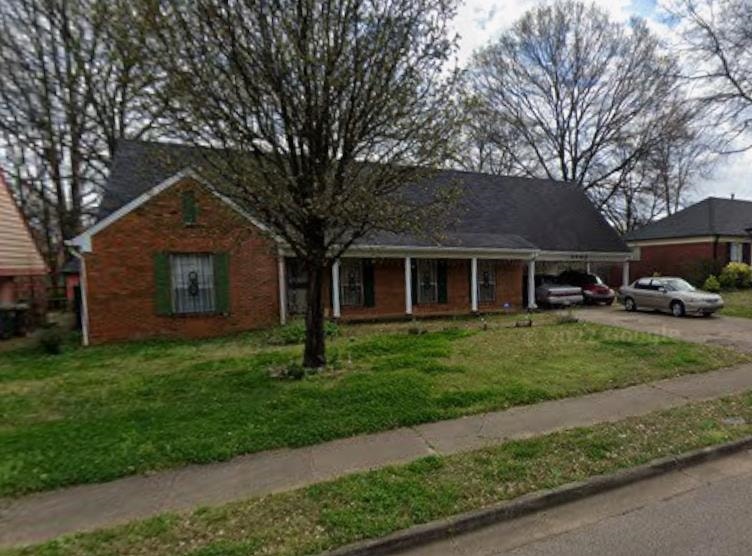 3702 Clarke Road Memphis, TN 38115 - Photo 1 of 1 Brick ranch-style home featuring a covered front porch with white columns, green window shutters, and a dark shingle roof