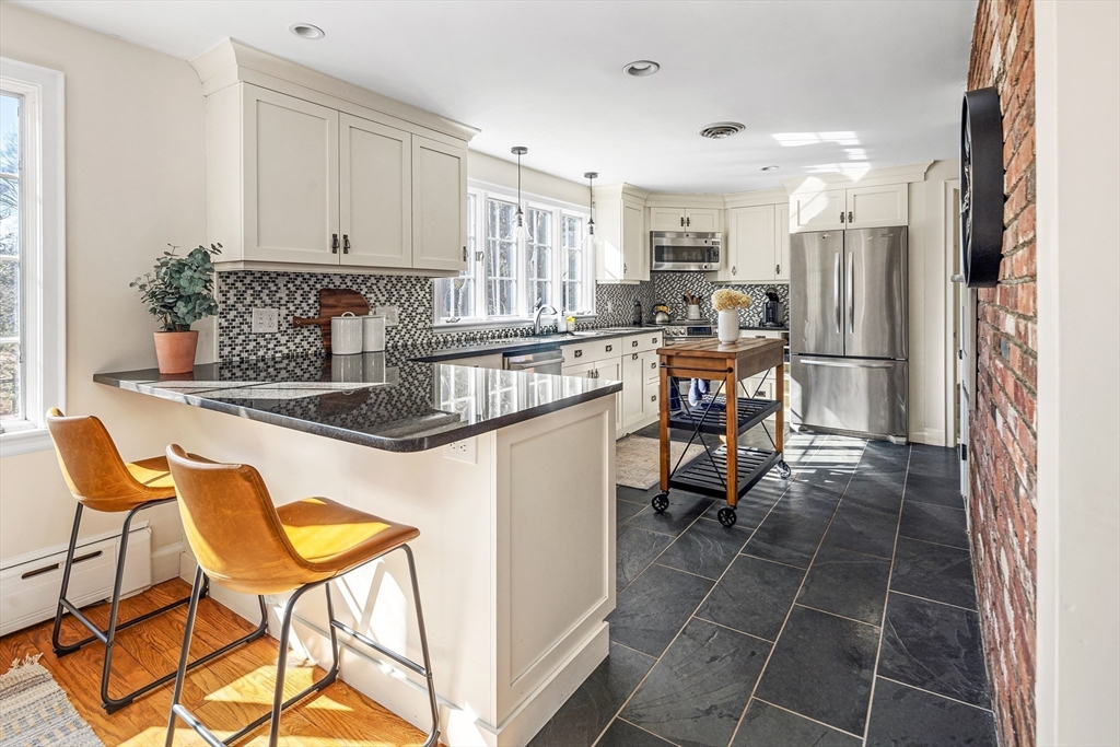 36 Howland Lane Hingham, MA 02043 - Photo 8 of 33 a kitchen with stainless steel appliances granite countertop a table chairs and a refrigerator