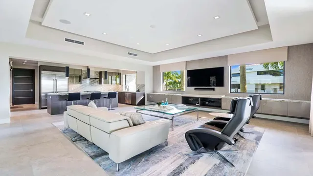 a living room with furniture a flat screen tv and a large window